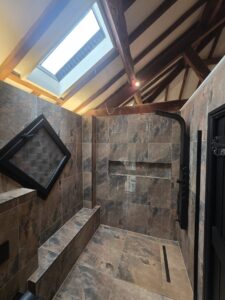 A recent bathroom installation completed by Elgar Services in Worcester, featuring a spacious walk-in shower, slate effect tiles and modern black fittings.