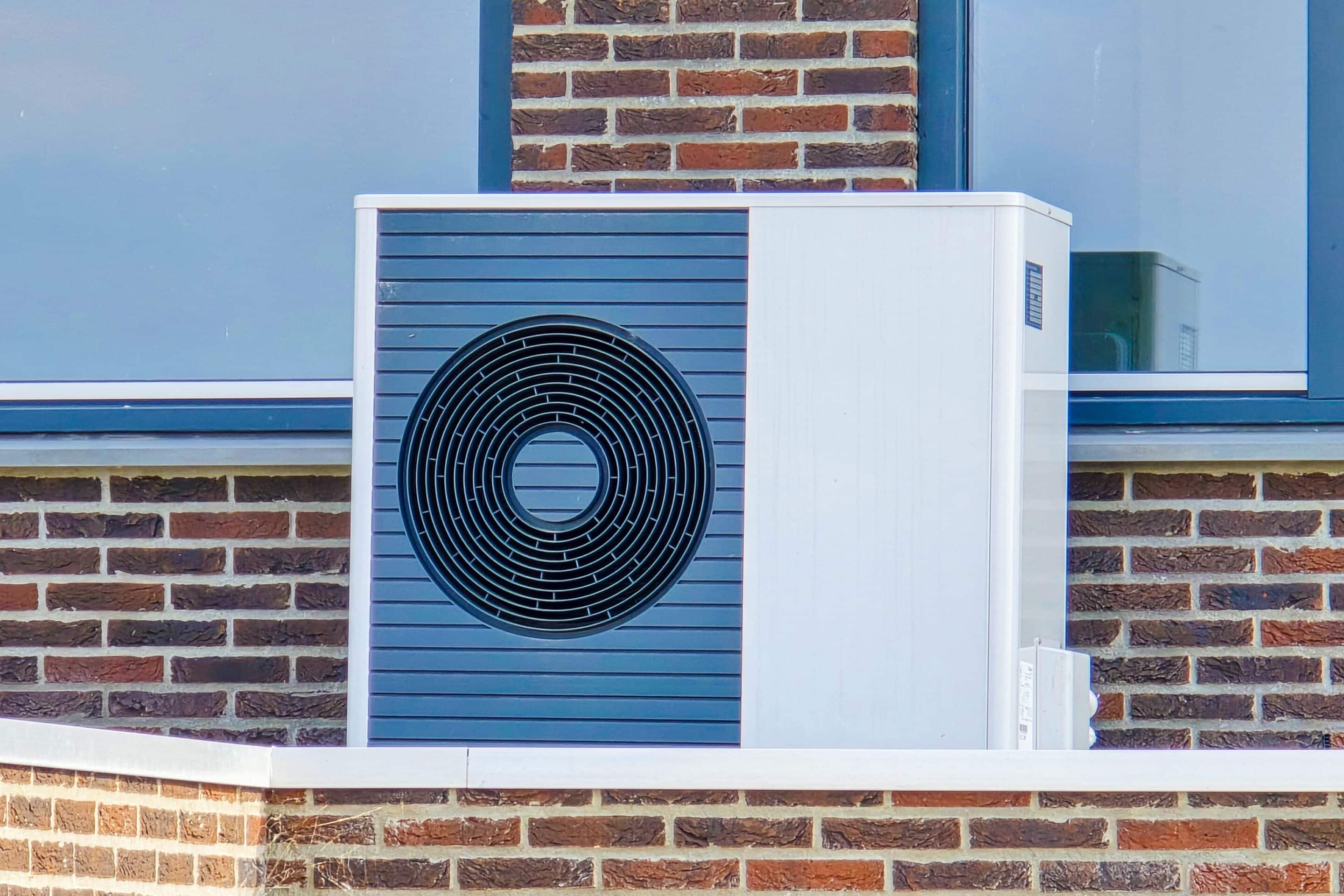 technician maintaining a heat pump