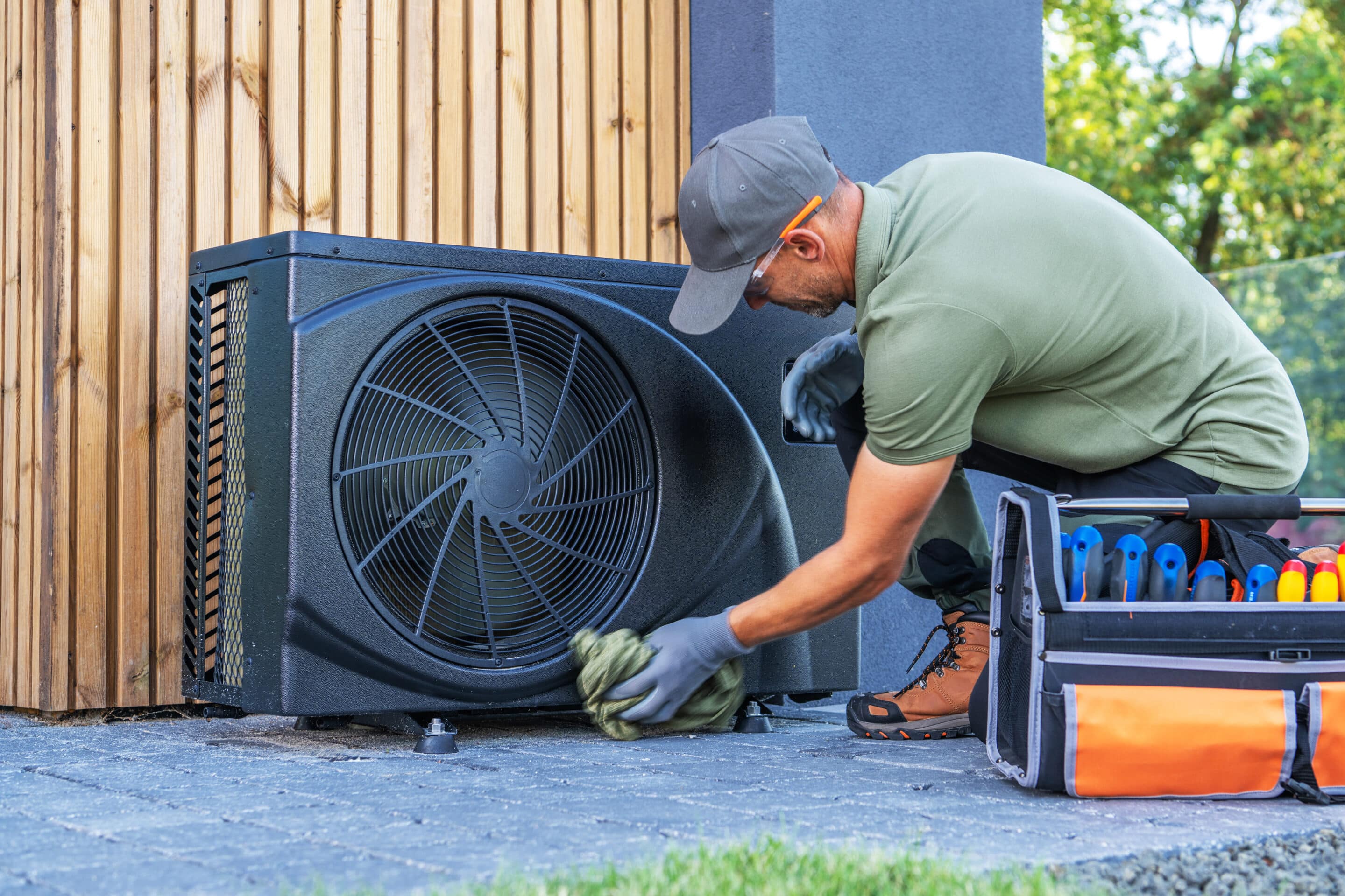 technician maintaining a heat pump